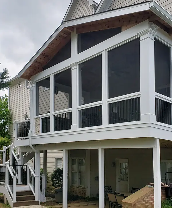 Custom screened porch addition with gable roof, white columns and elevated outdoor living space.