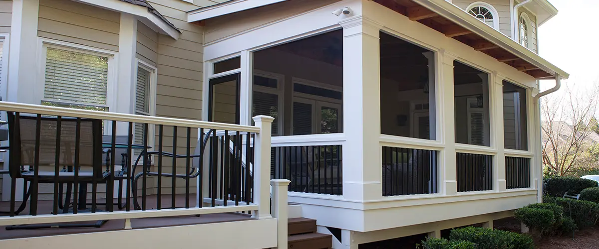 Screened porch addition with composite deck, black railings and covered outdoor living space.