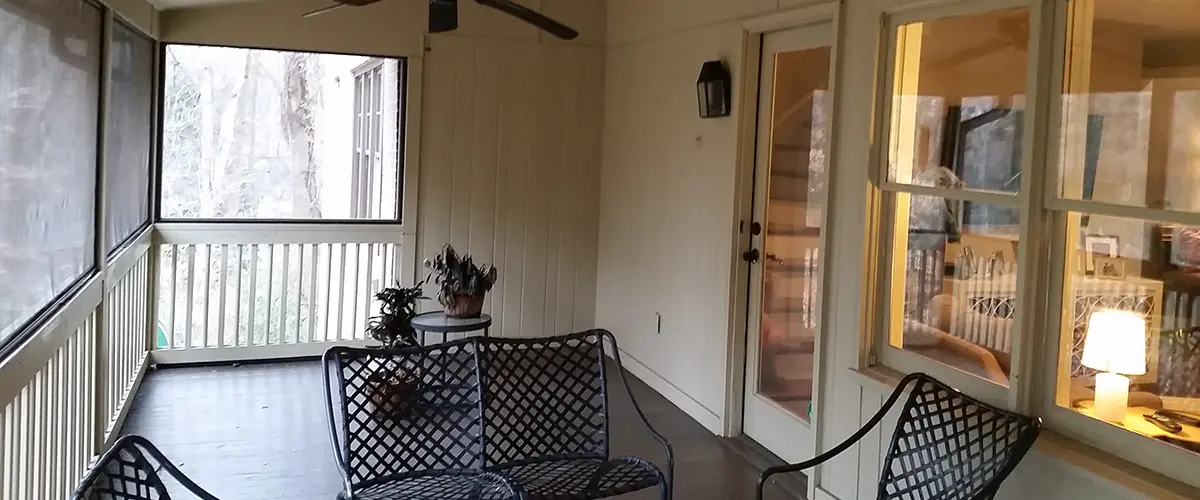 Screened porch interior with ceiling fans, outdoor seating and spacious covered living area.
