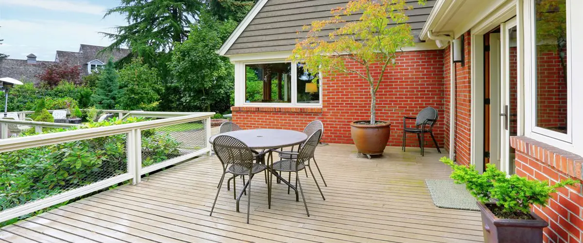Spacious backyard deck with outdoor dining area, cable railing and garden views.