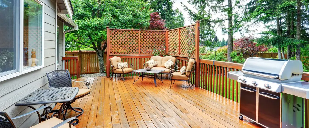 Spacious wood deck with outdoor seating, privacy lattice and built-in grilling area.