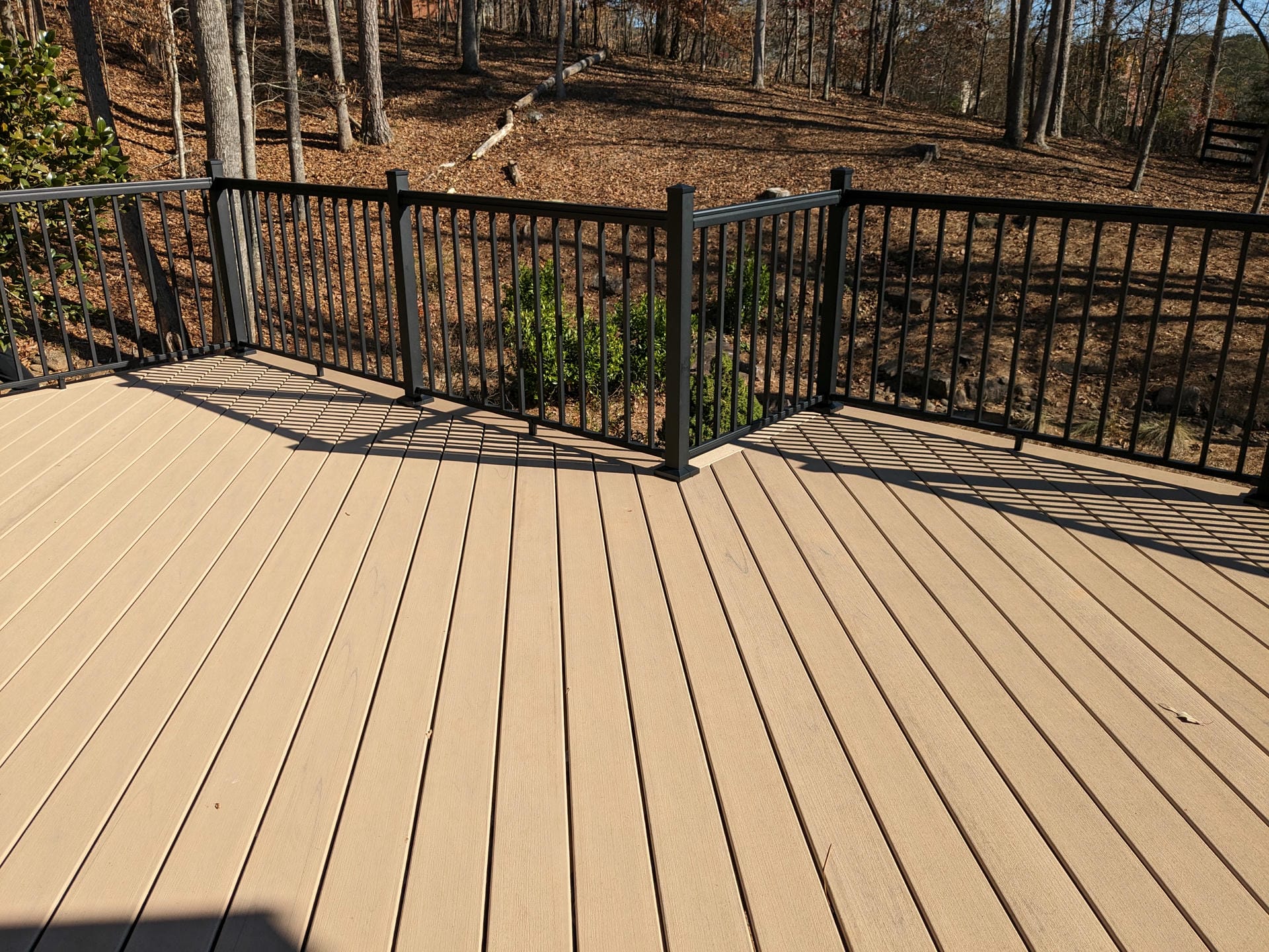 Black aluminum deck railing with a gate section on a composite deck