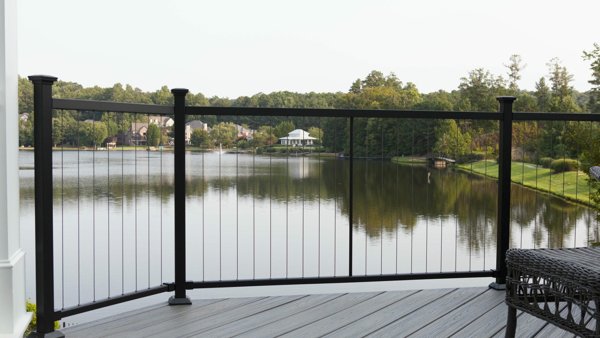 Vertical cable railing on a lakefront deck at dusk