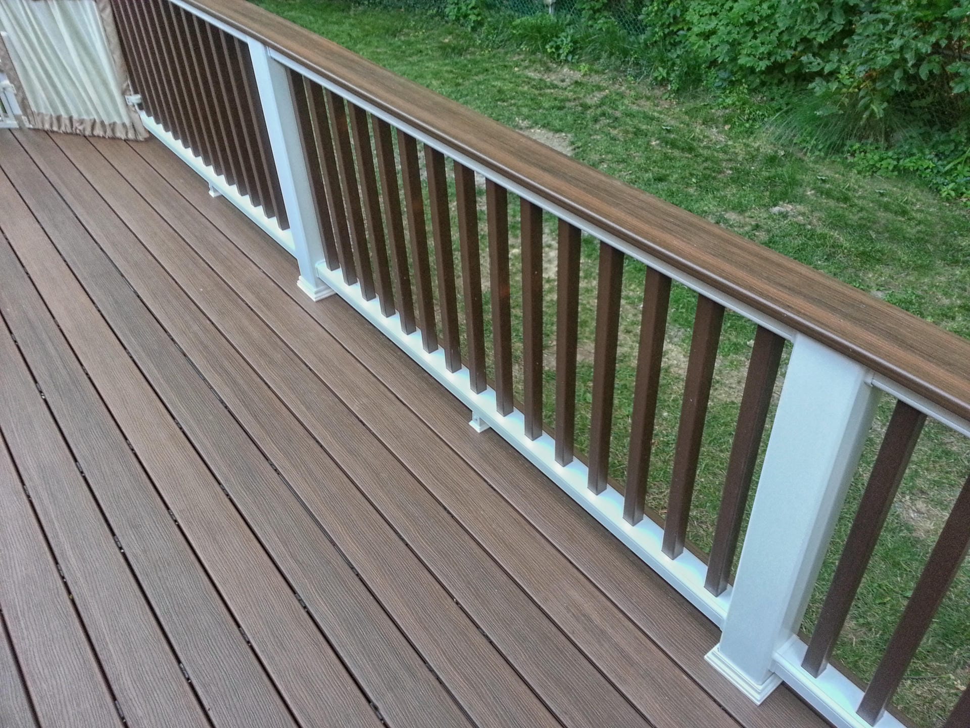 Composite deck railing with brown balusters and white posts