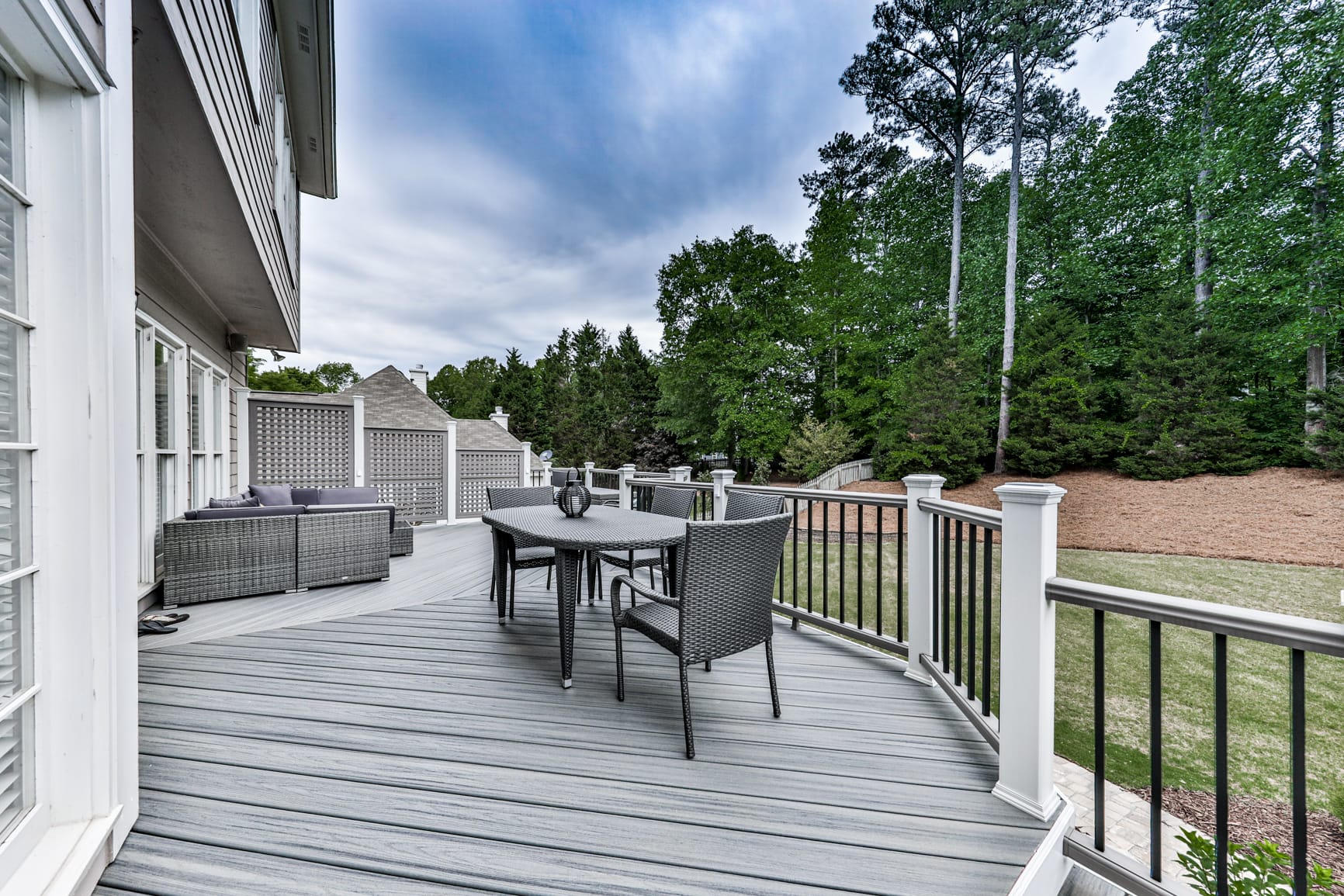 Gray composite deck with white railing posts and black round balusters