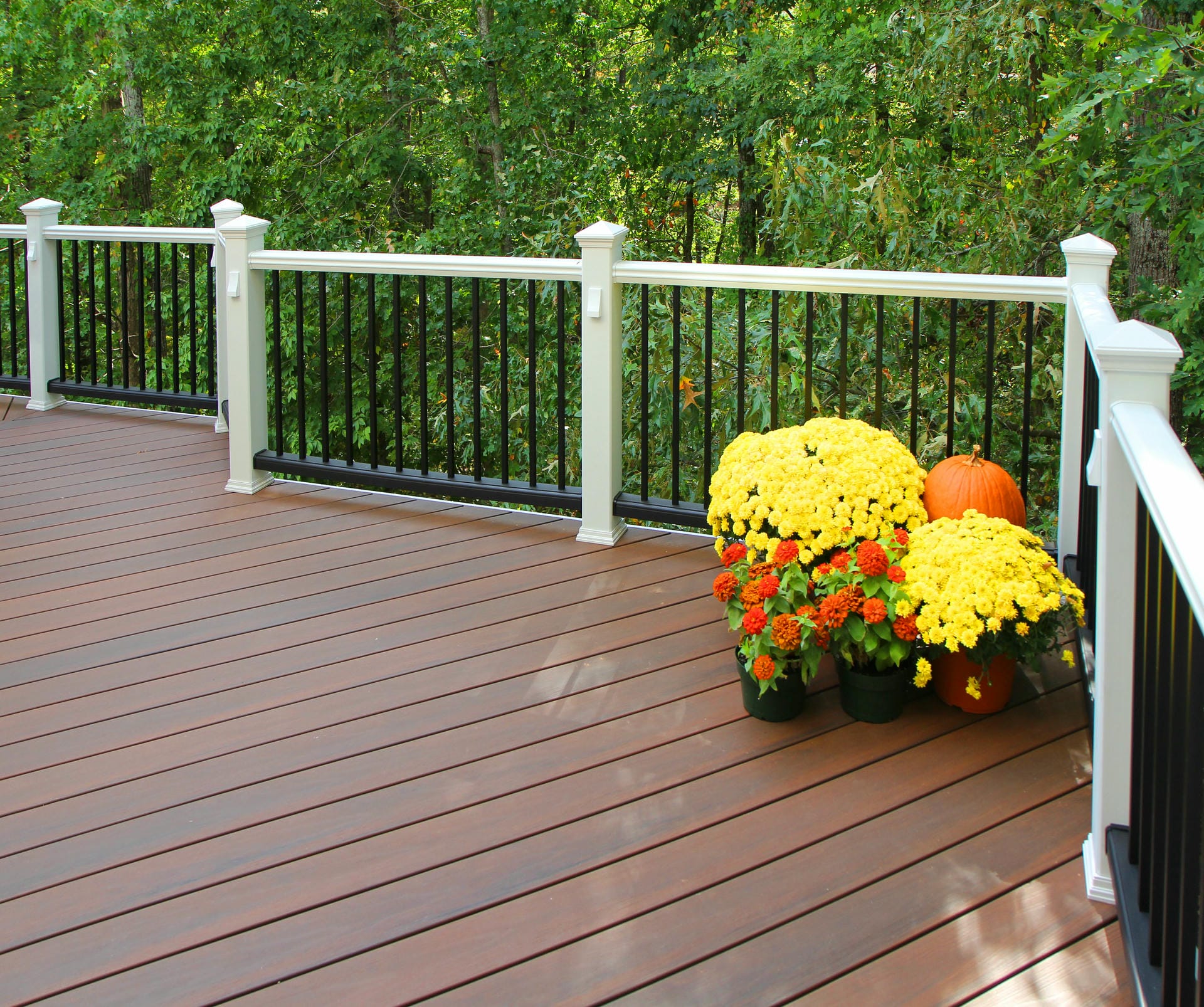 Reddish brown composite deck with white railing posts on an East Cobb home