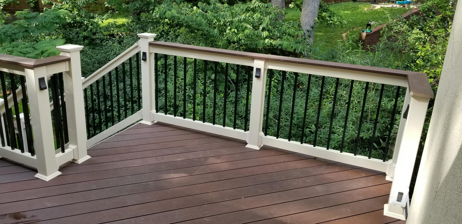 Dark mahogany composite deck with white posts and black balusters