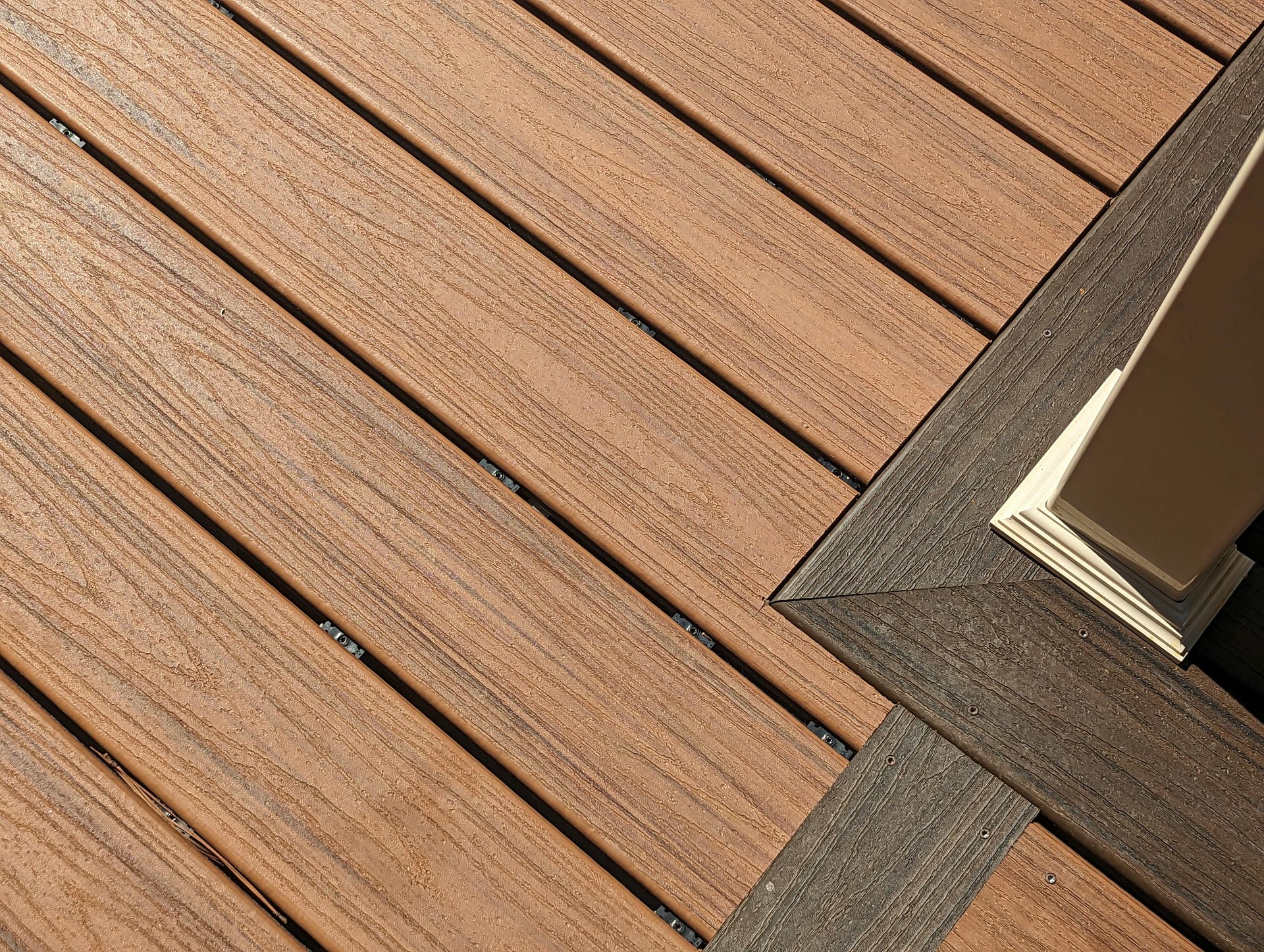 Close view of composite deck board woodgrain with a contrasting picture frame border