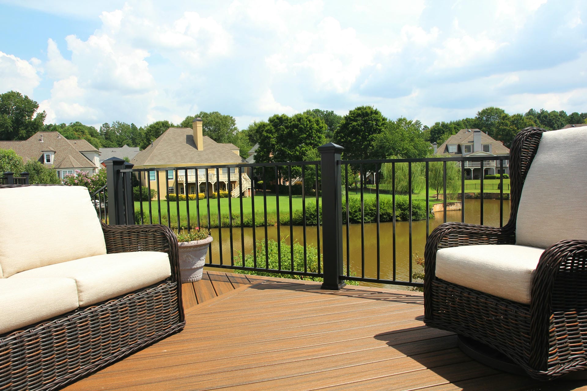 Deck railing combining Trex post sleeves with Fortress rail panels overlooking a pond