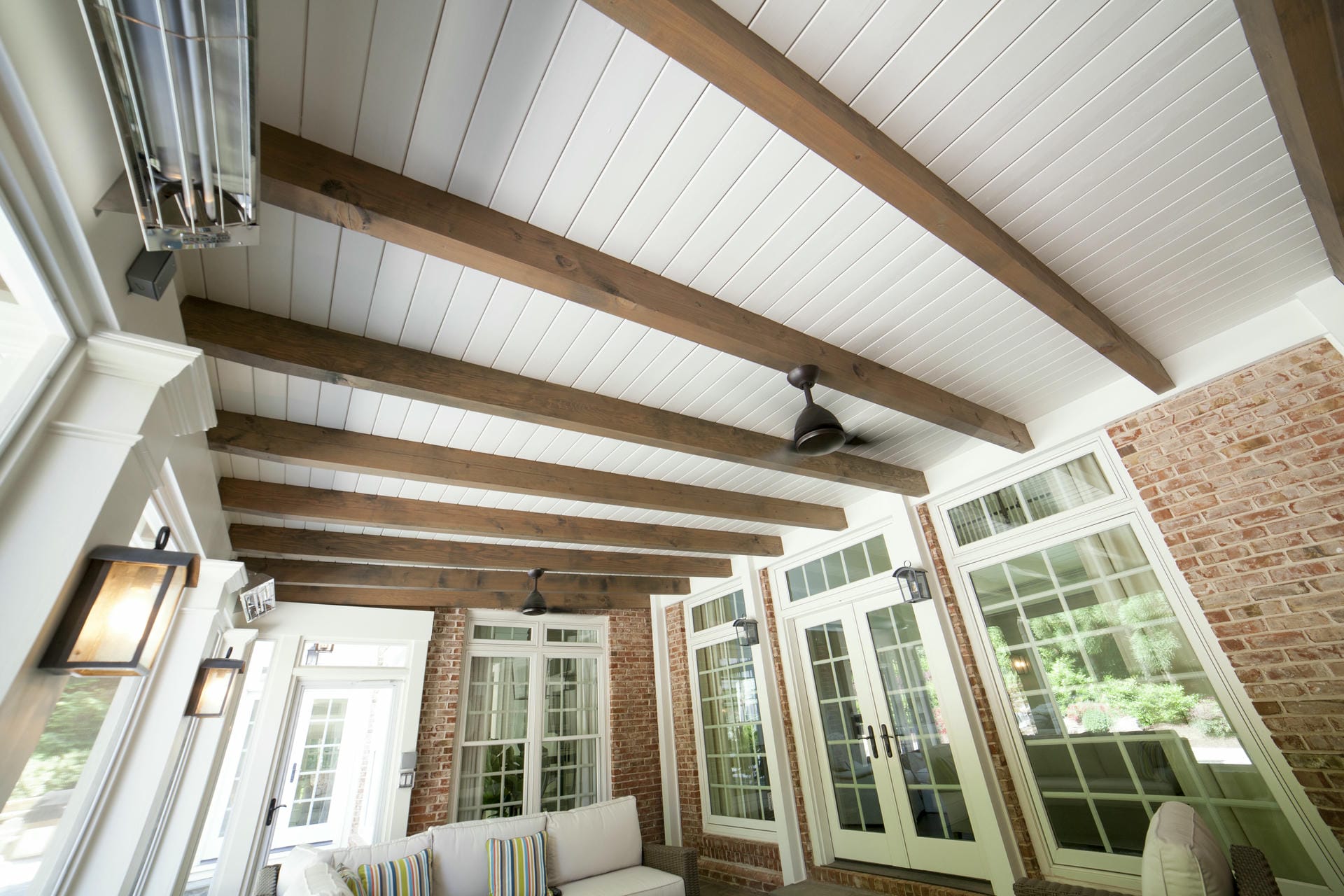 Finished porch interior with warm cedar rafters overhead