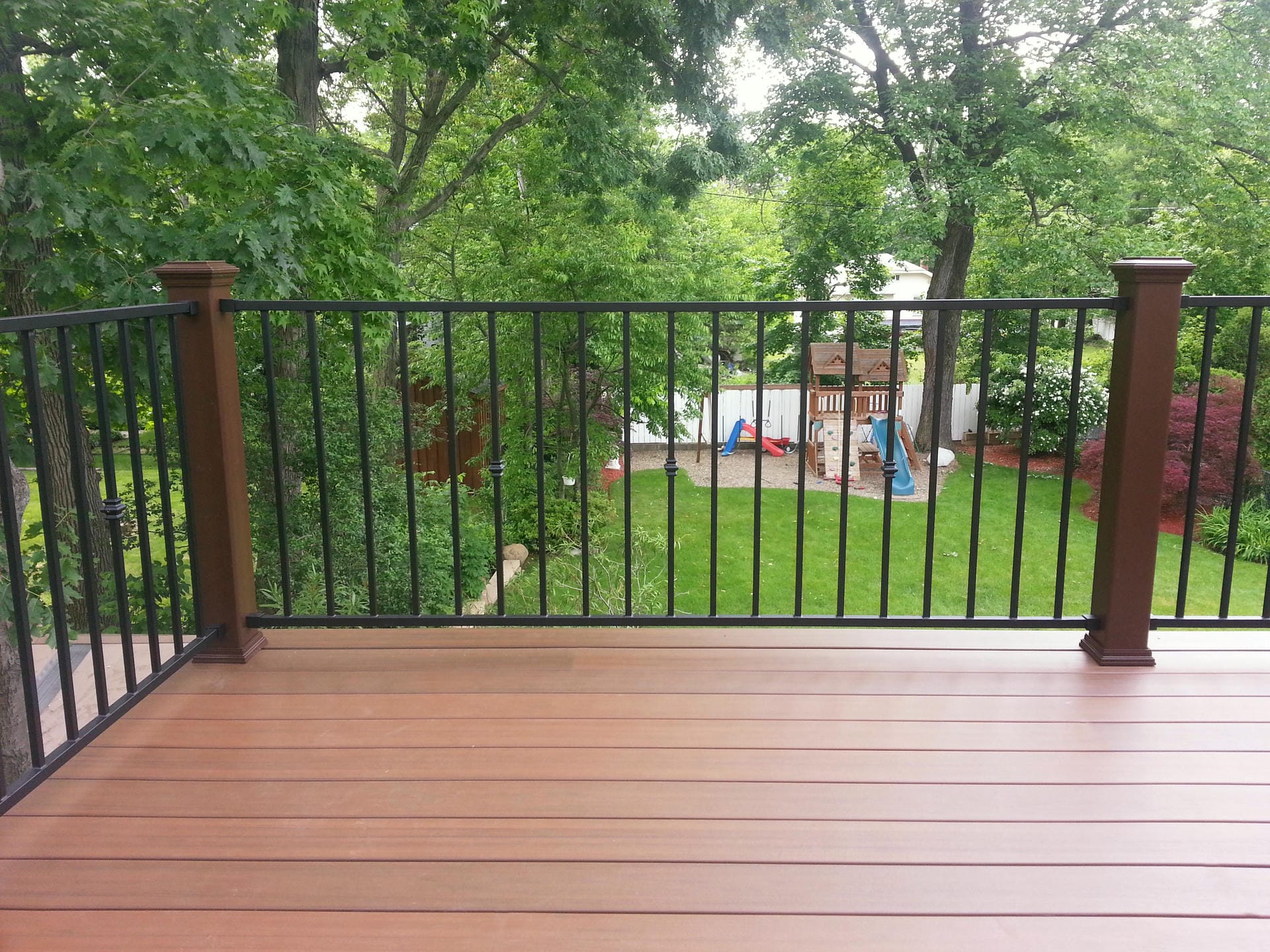 Fortress Fe26 steel deck railing with black balusters above a backyard lawn