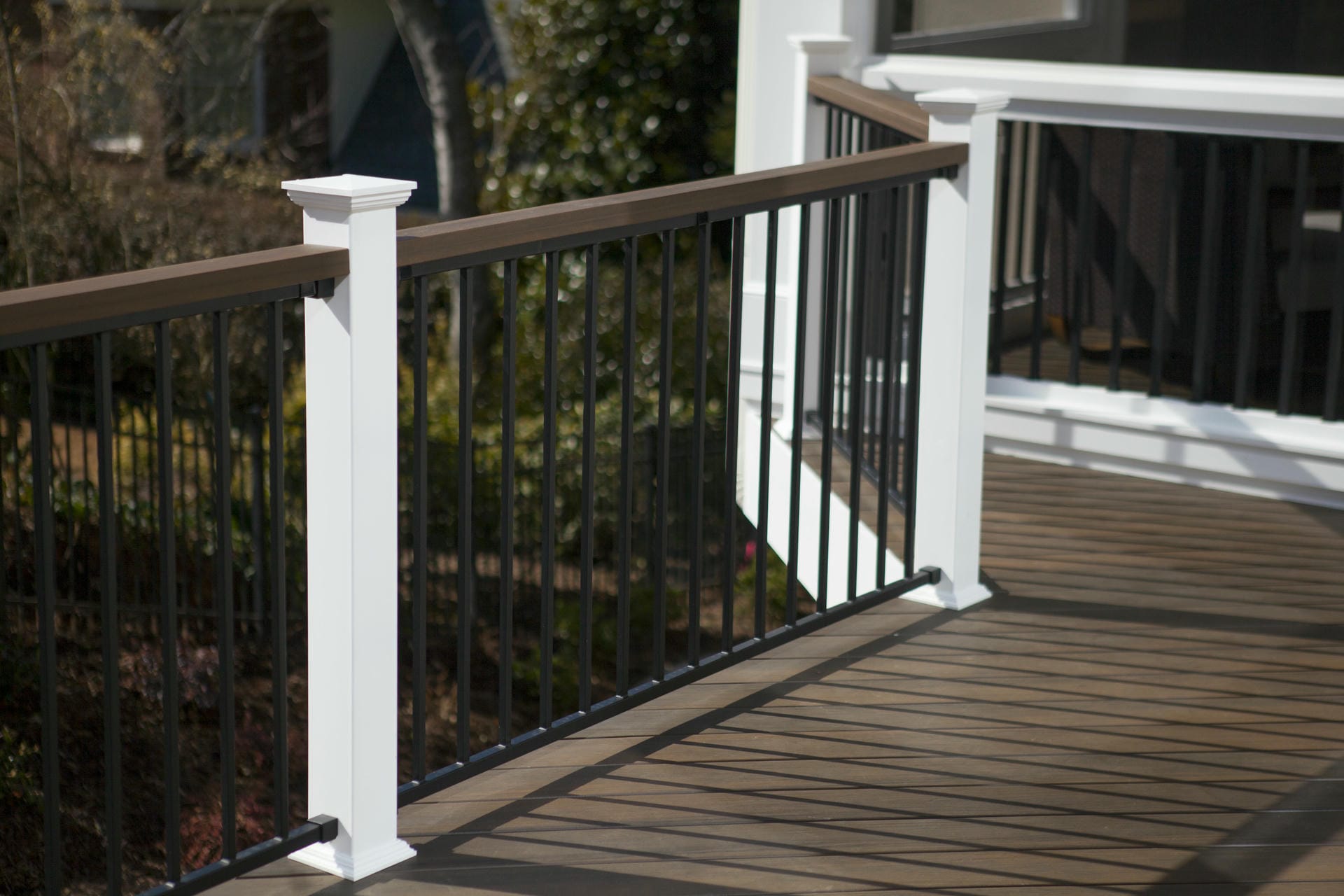 Fortress Fe26 steel railing detail with a white post and dark composite top rail