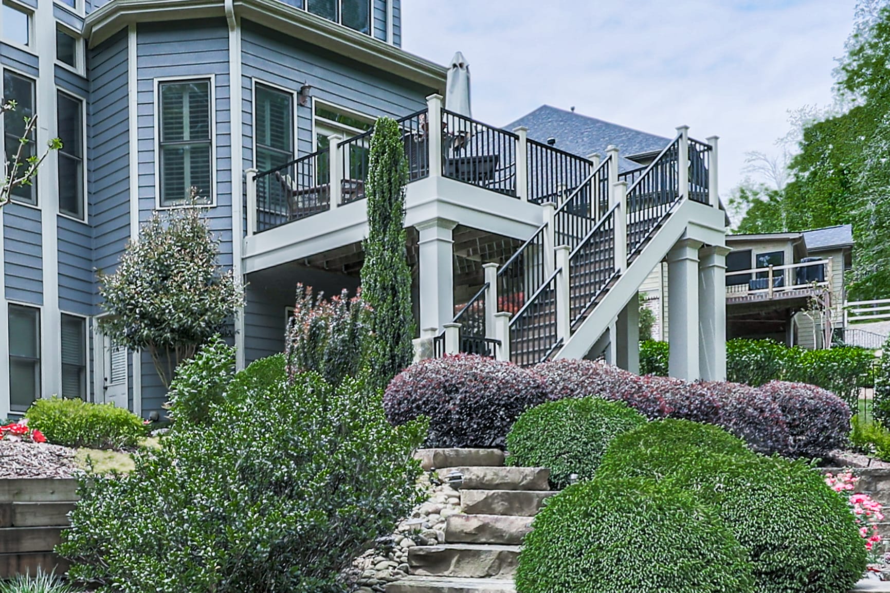 Elevated deck with black railing and a white staircase on a Johns Creek home