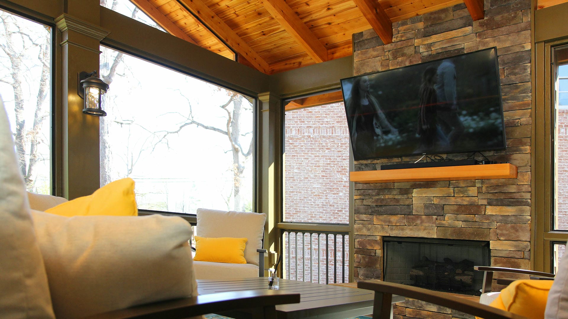Screened porch with a custom fireplace as the focal point