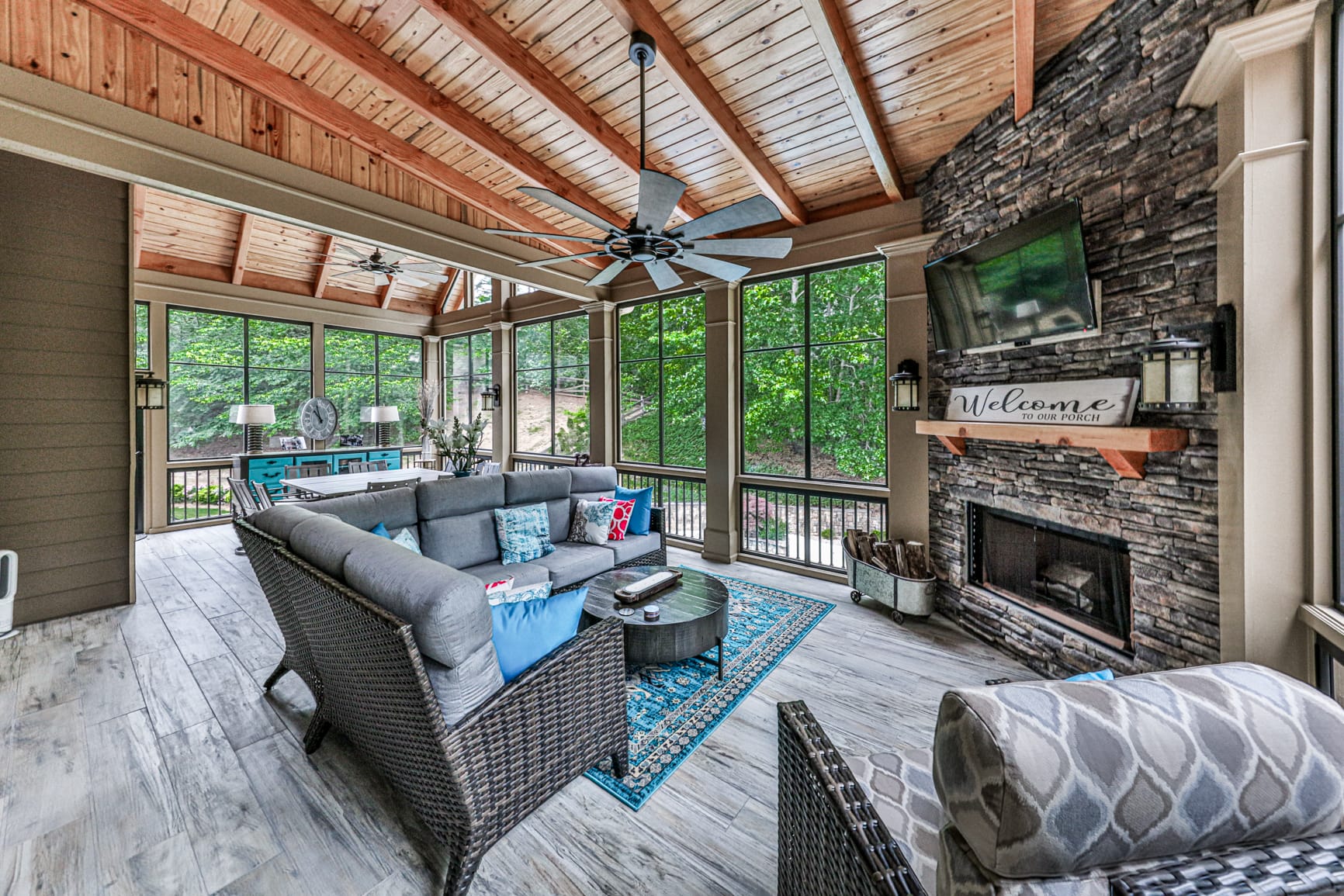 Stacked stone porch fireplace with a mounted television above