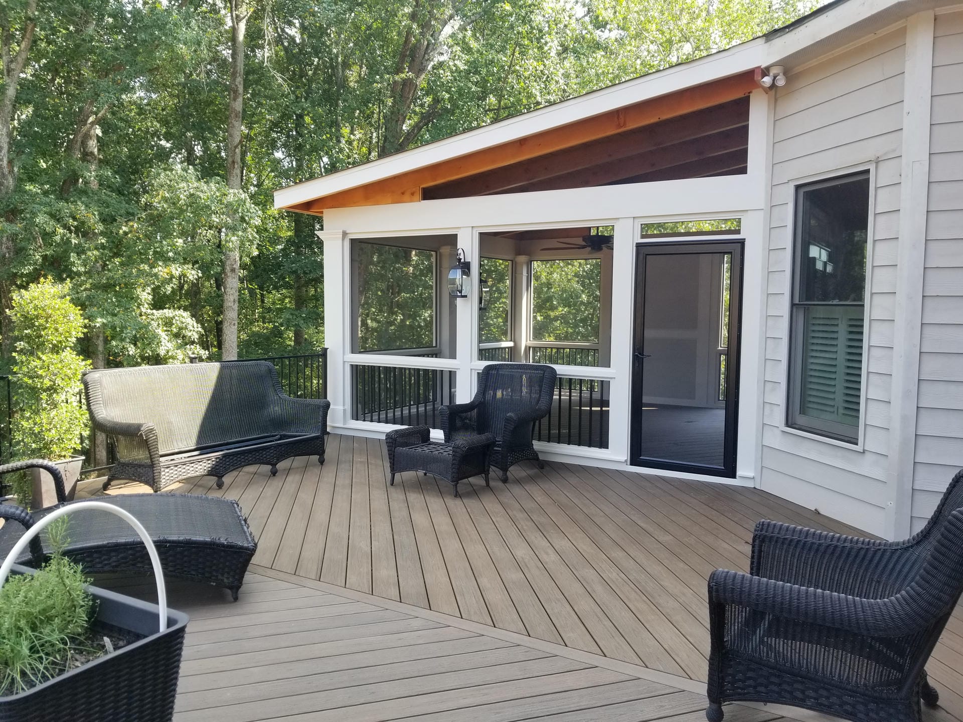 Screened porch under a single slope shed roof with a stained wood soffit