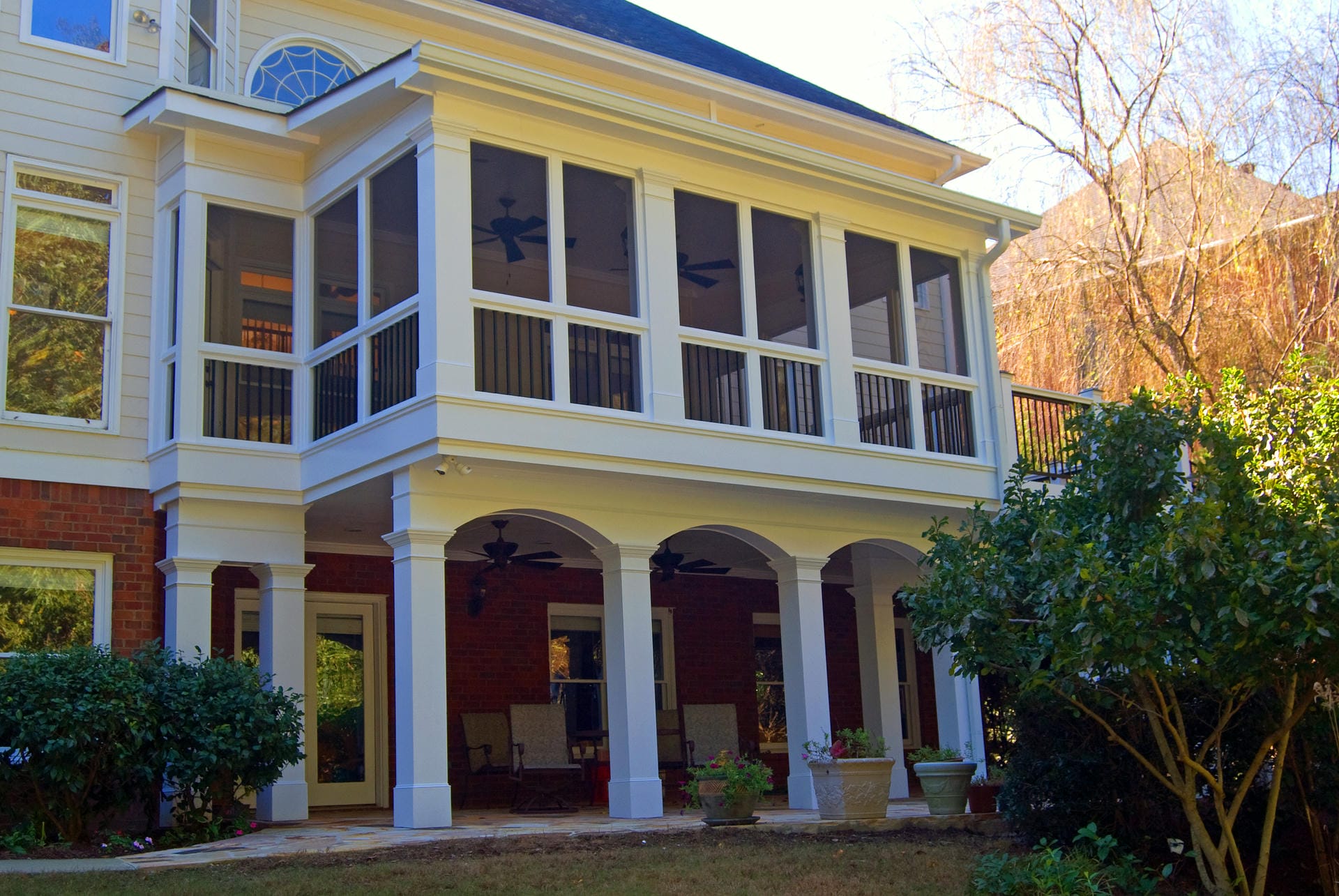Upper screened porch with a shed roof above an arched lower porch in Alpharetta