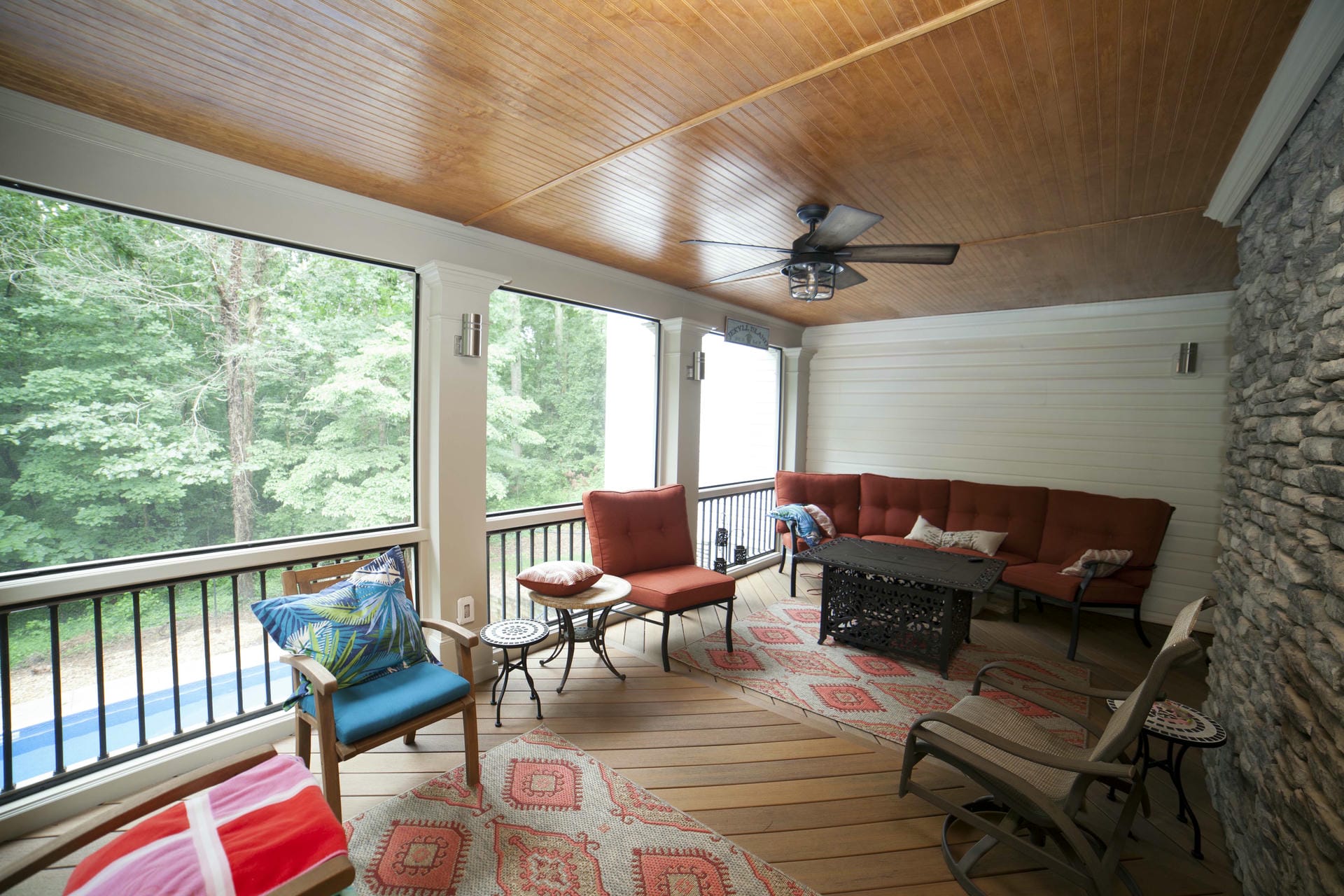 Warm wood tongue and groove ceiling above a furnished screened porch