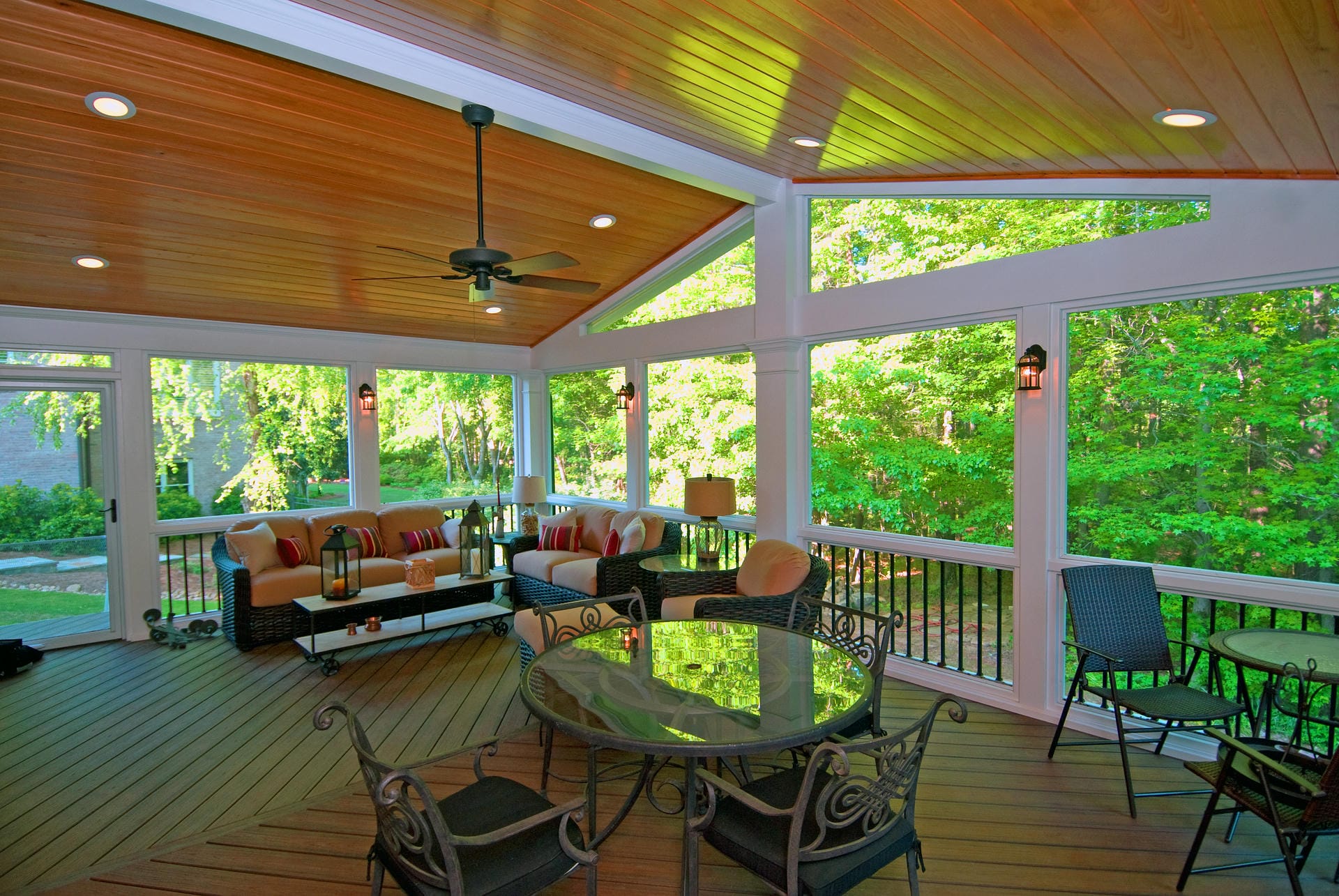 Screened porch interior with a wood plank ceiling and ceiling fan