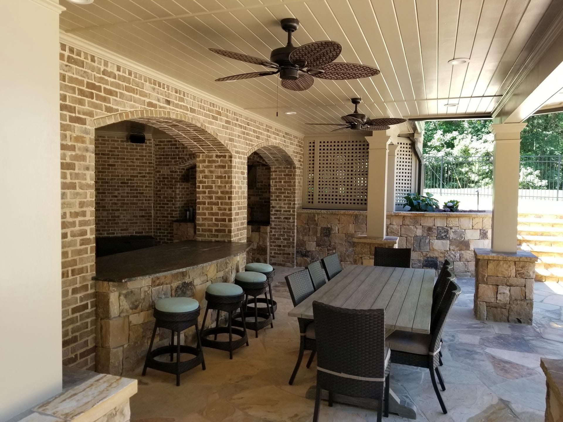 Dry space under a deck with a brick bar, dining table and stained wood ceiling