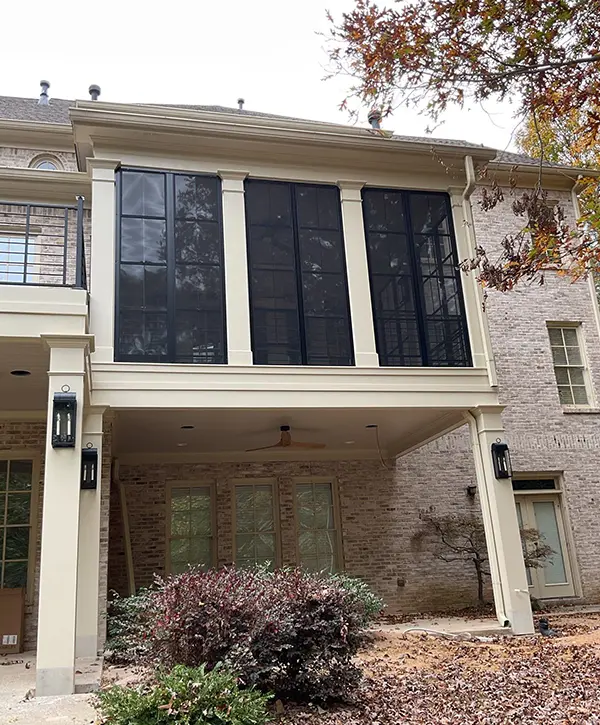 Custom screened porch addition with black screens and covered patio below