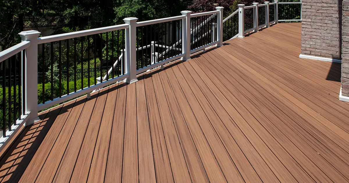Large composite deck with brown decking, white posts, black railings and stairs leading to the backyard