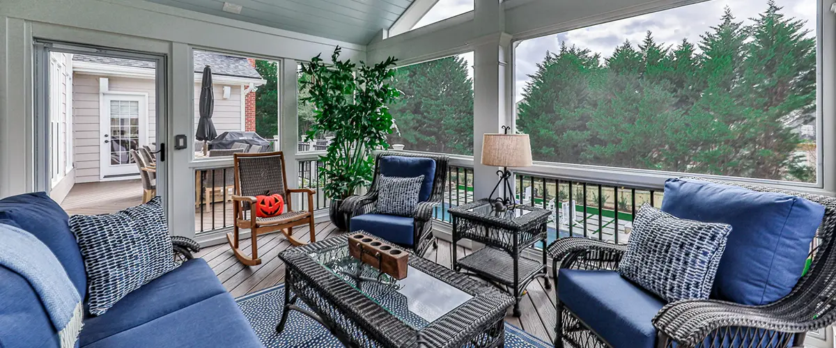 Screened porch with vaulted ceiling, ceiling fan and comfortable outdoor seating overlooking the backyard
