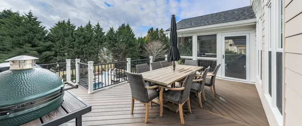 Backyard deck with outdoor dining area, composite decking, railing, and built-in grill space