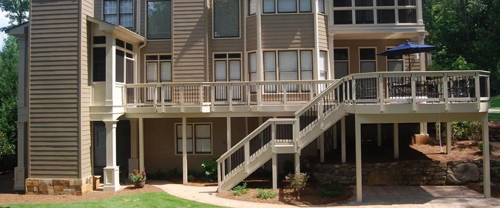 Large elevated backyard deck with stairs, black railings, and covered outdoor living space